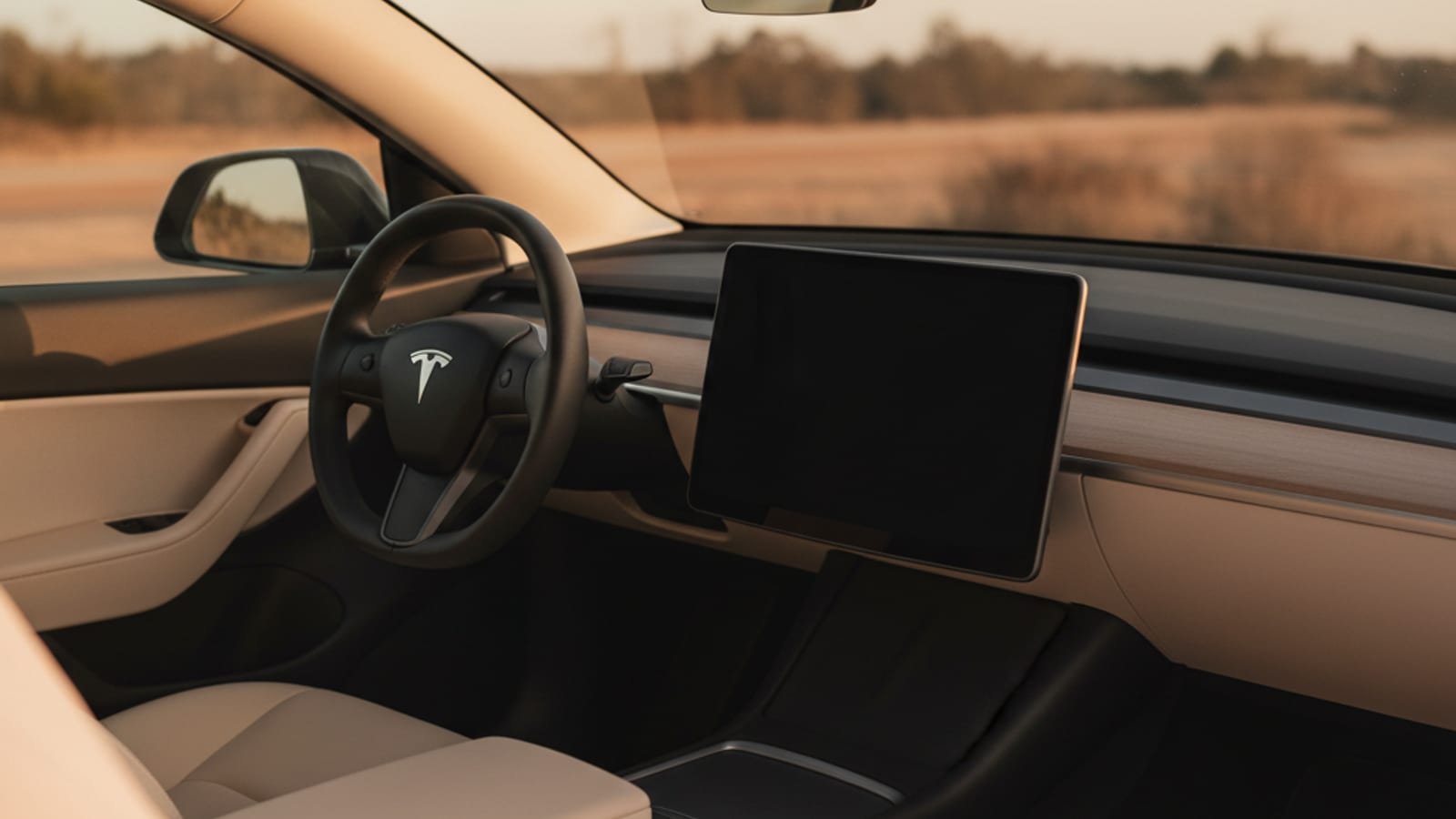 A Tesla Model Y with a completely black center infotainment screen visible through the windshield indicating a dead 12V battery